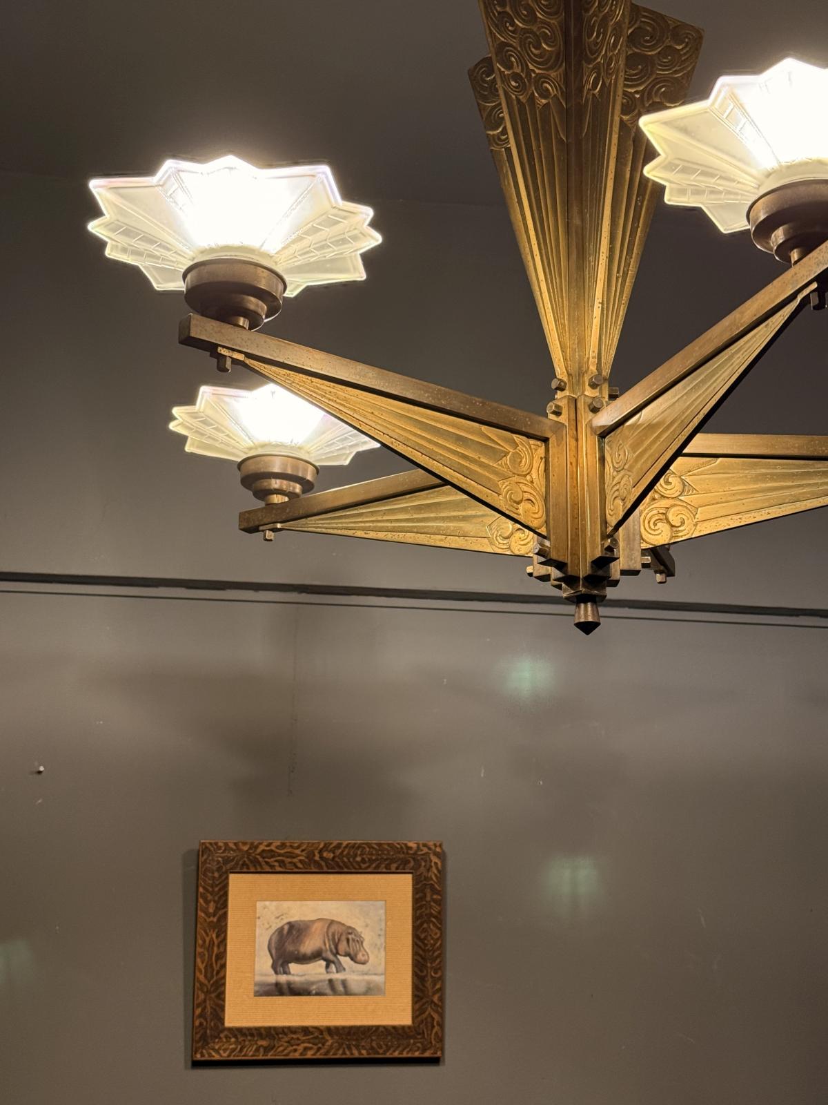 Lustru masiv Art Deco din alamă cu abajururi din sticlă mată, cablaj nou. Dimensiuni: 76 x 80 cm. Obiect rar disponibil în Sertar Magic București.