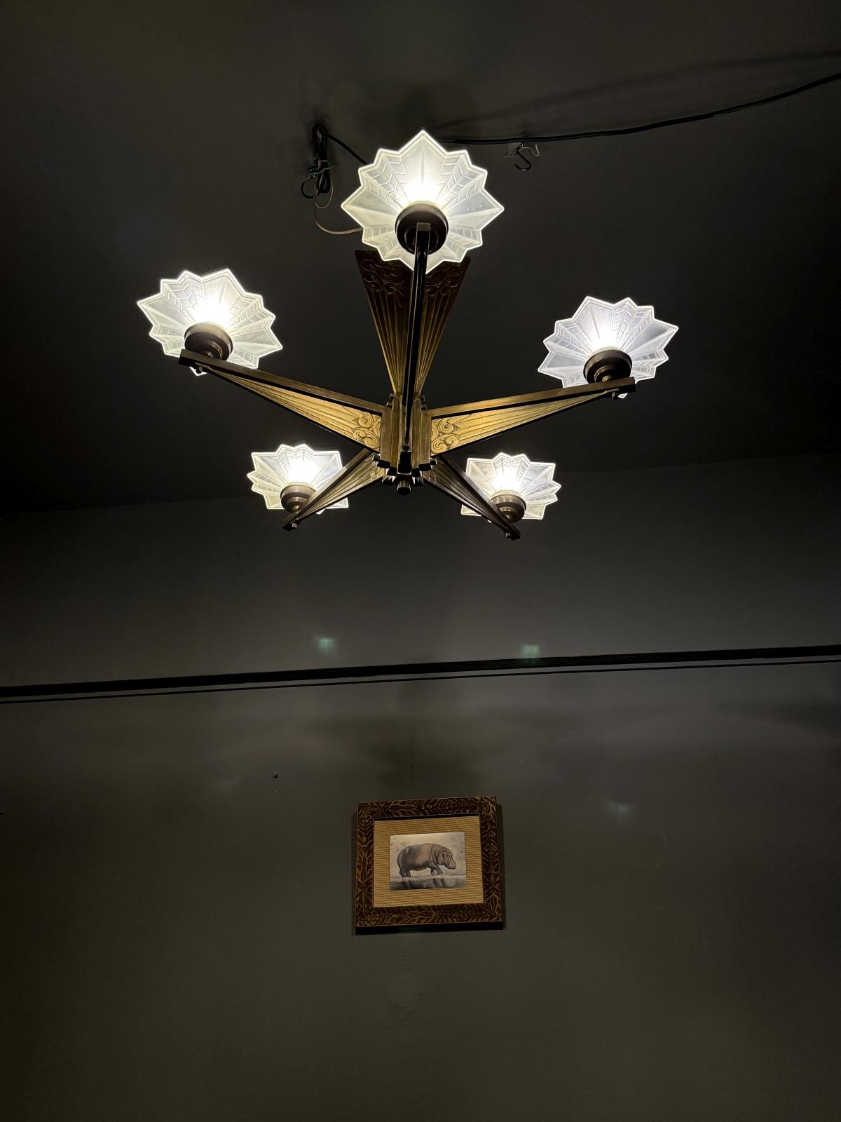 Lustru masiv Art Deco din alamă cu abajururi din sticlă mată, cablaj nou. Dimensiuni: 76 x 80 cm. Obiect rar disponibil în Sertar Magic București.