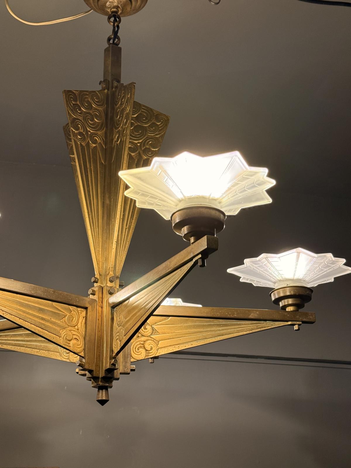 Lustru masiv Art Deco din alamă cu abajururi din sticlă mată, cablaj nou. Dimensiuni: 76 x 80 cm. Obiect rar disponibil în Sertar Magic București.