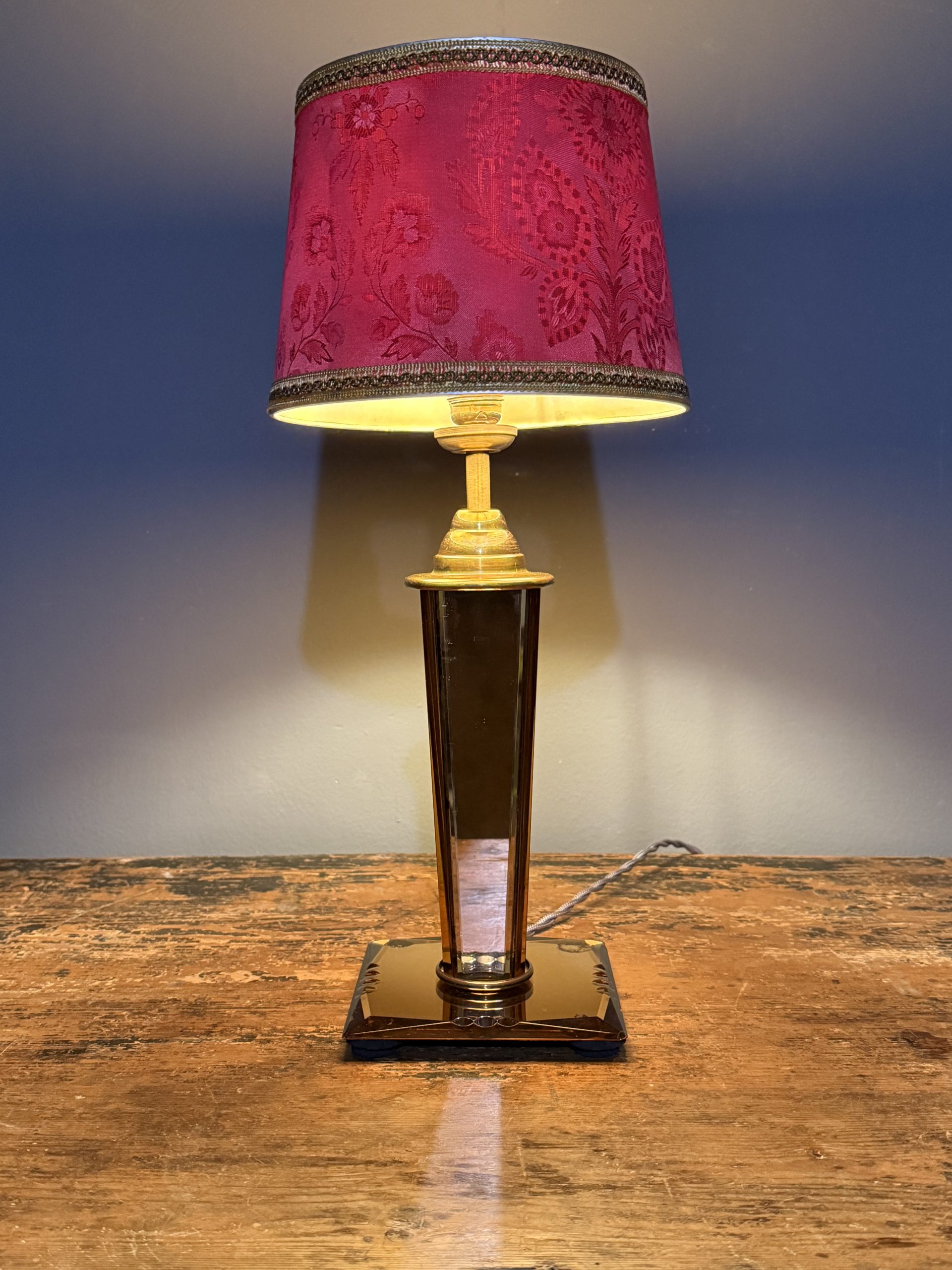 Lampă de masă Art Deco recondiționată, cu picior din sticlă oglindată fațetată, tentă roz-ambra și abajur textil vechi. sertar magic București