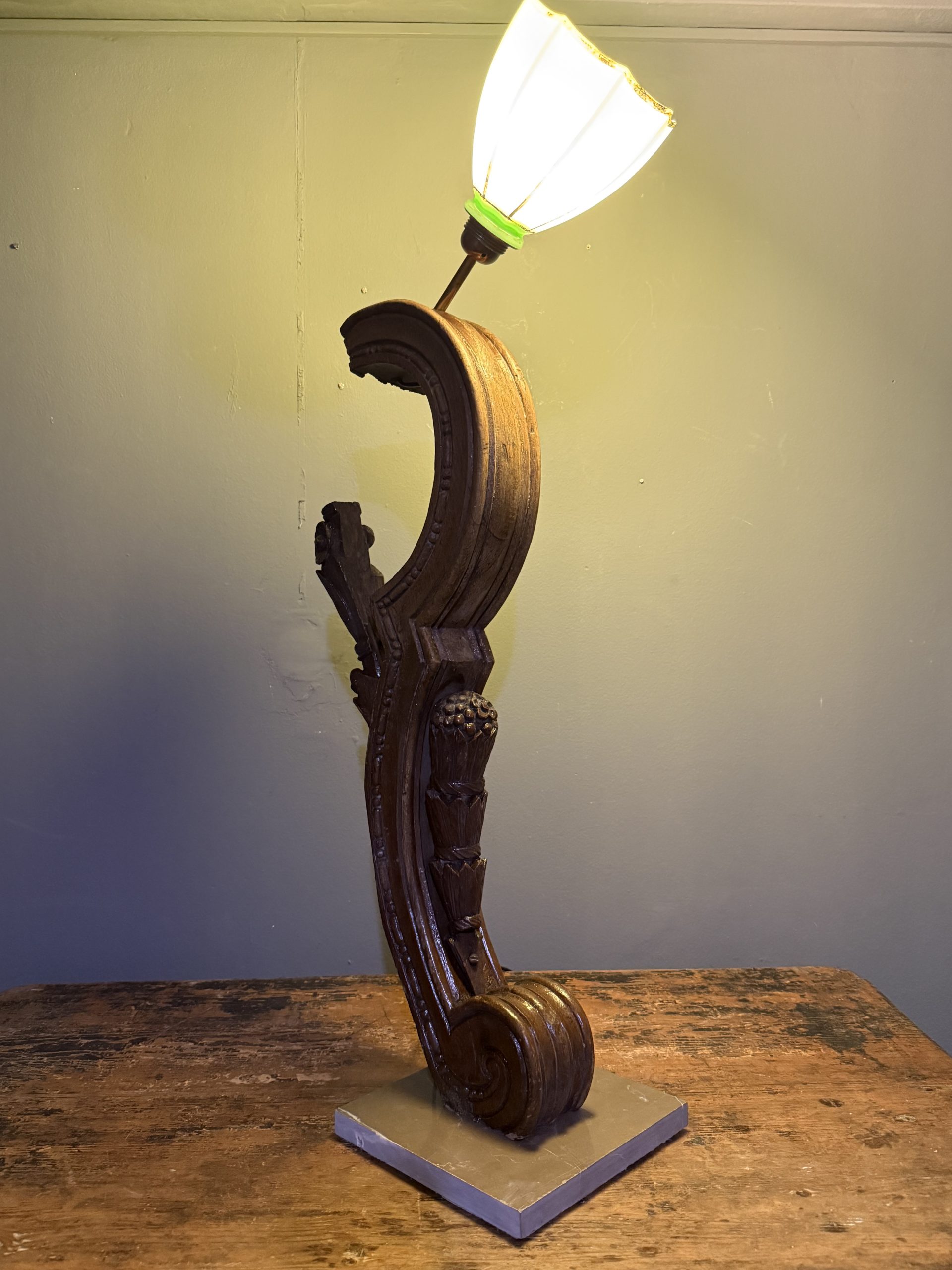 Lampă sculpturală realizată din lemn vechi sculptat și abajur din opalină verde, pe bază de marmură.