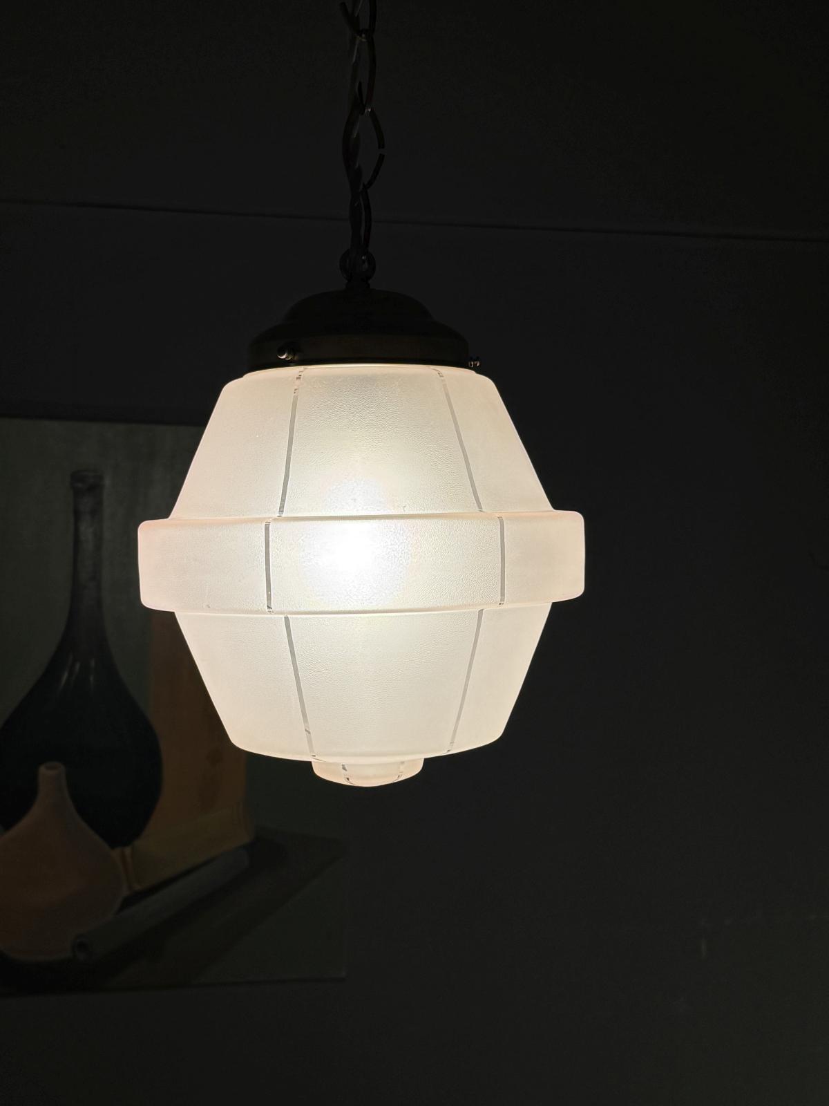 Lustră Art Deco din sticlă sablată rozalie cu detalii geometrice și elemente din alamă lustruită.