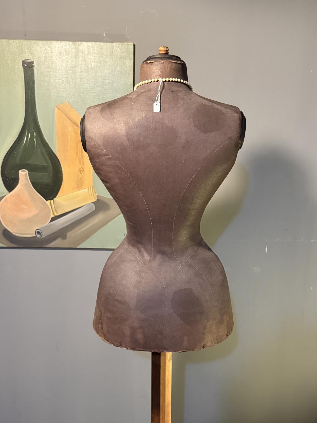 Manechin de croitorie feminin vechi, din carton presat și material textil, montat pe suport original din lemn și metal.