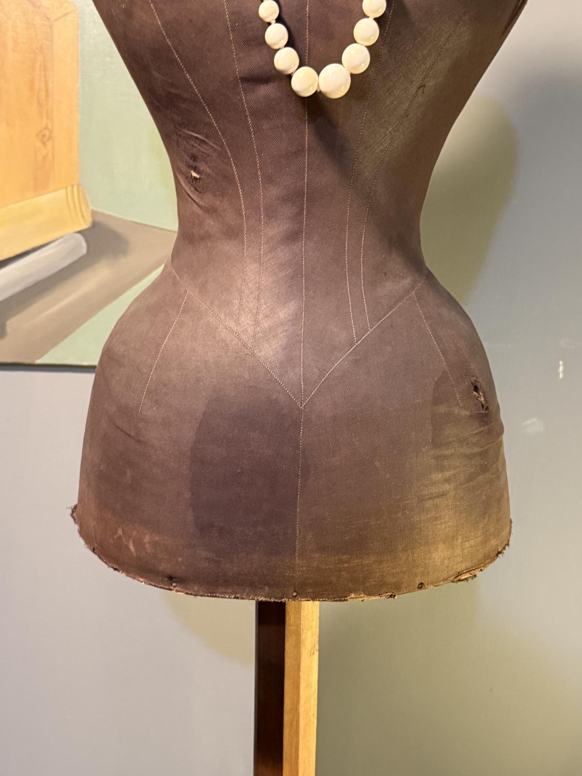 Manechin de croitorie feminin vechi, din carton presat și material textil, montat pe suport original din lemn și metal.