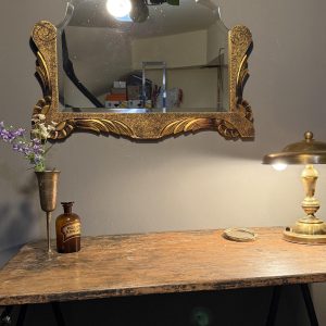 Oglindă veche biseautată cu formă conturată și decor auriu cu frunze și volute. Piesă în stare foarte bună, 76 × 58 cm.