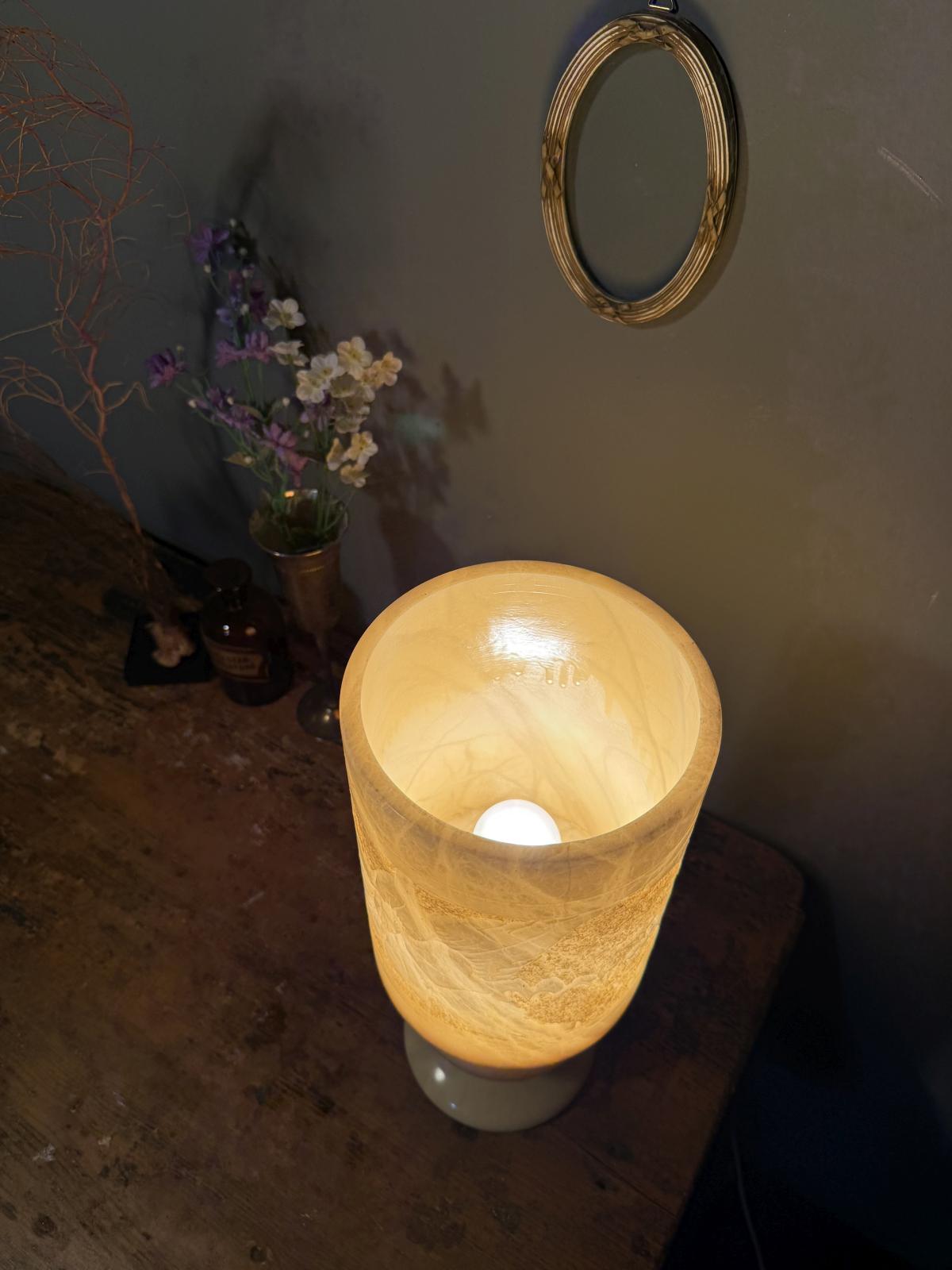 Lampă de masă din alabastru masiv, cu abajur cilindric sculptat cu motive florale. Înălțime 39,5 cm, stare foarte bună.