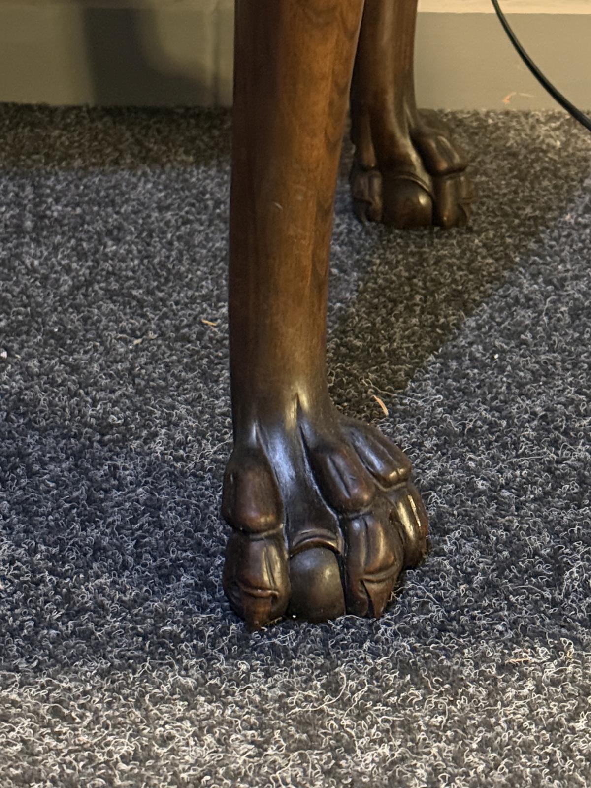 Masă rotundă veche din lemn, cu blat furniruit, picioare sculptate terminate în formă de labă și placă protectoare din sticlă.