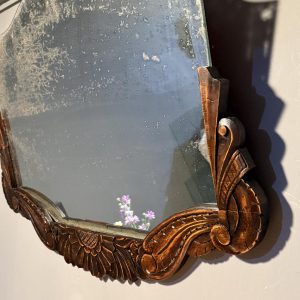 Oglindă veche de 78 × 54 cm, cu ramă sculptată din lemn și patină accentuată pe suprafața oglinzii. Rama a fost reparată.