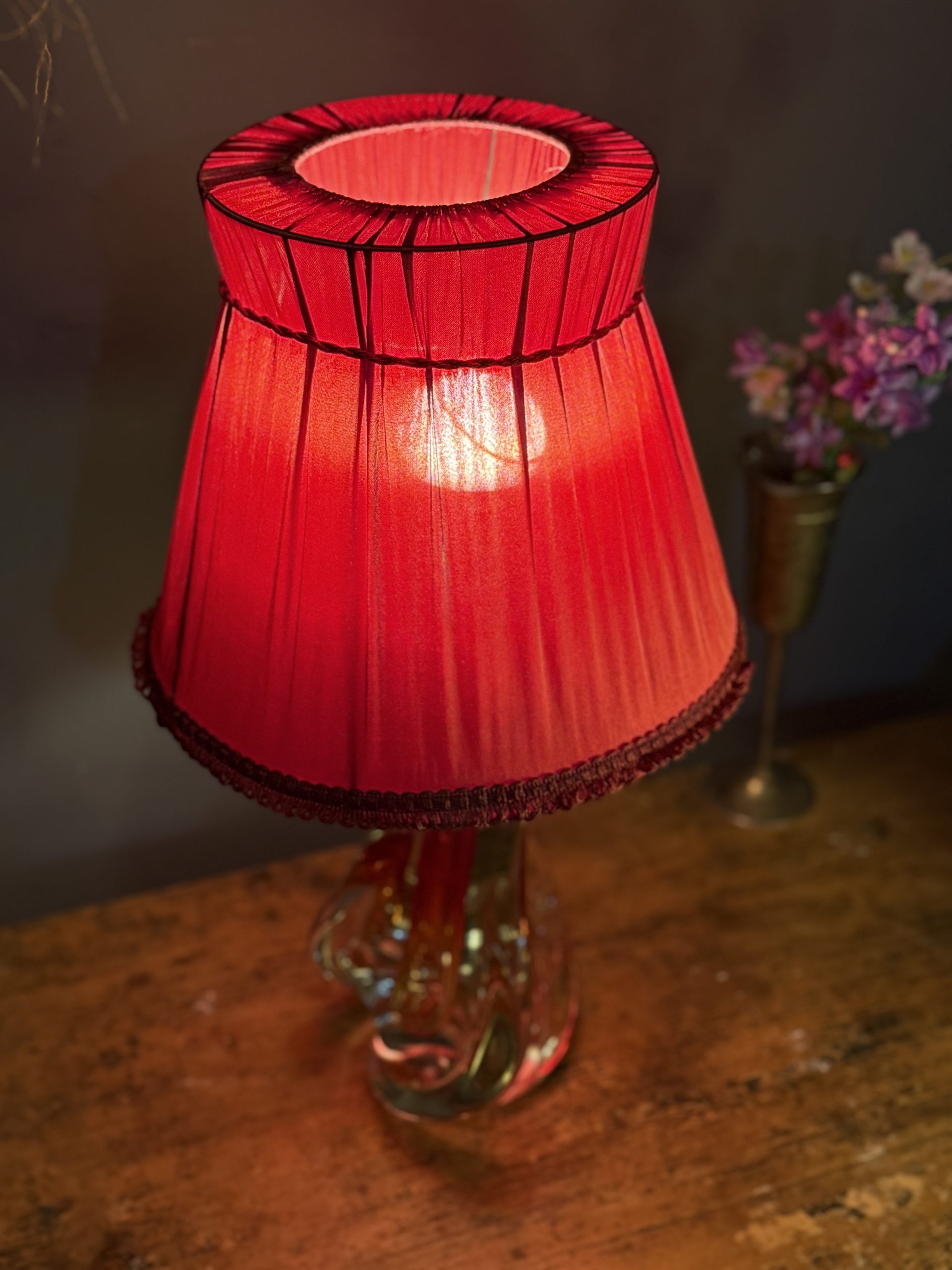 Lampă de masă din cristal masiv, cu formă sculpturală și abajur vechi din material textil roșu. Înălțime totală 47 cm.
