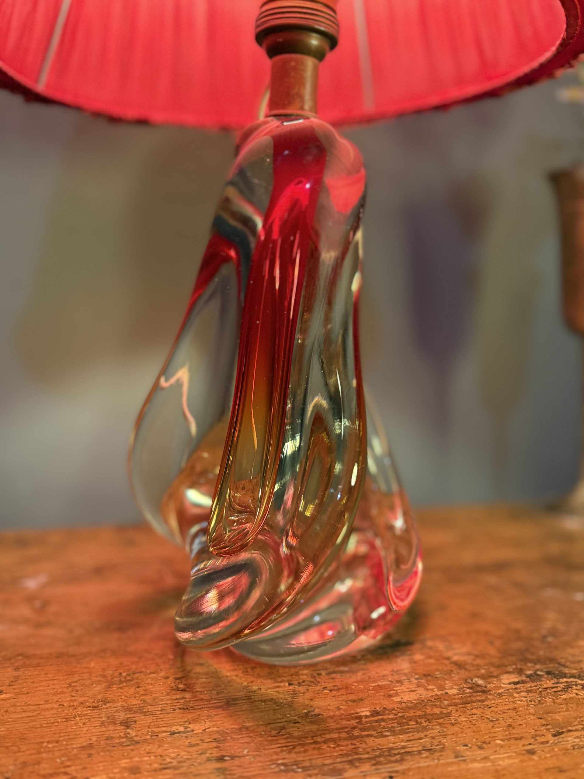 Lampă de masă din cristal masiv, cu formă sculpturală și abajur vechi din material textil roșu. Înălțime totală 47 cm.
