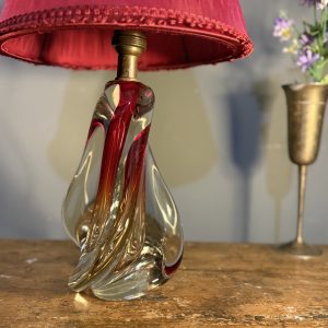 Lampă de masă din cristal masiv, cu formă sculpturală și abajur vechi din material textil roșu. Înălțime totală 47 cm.