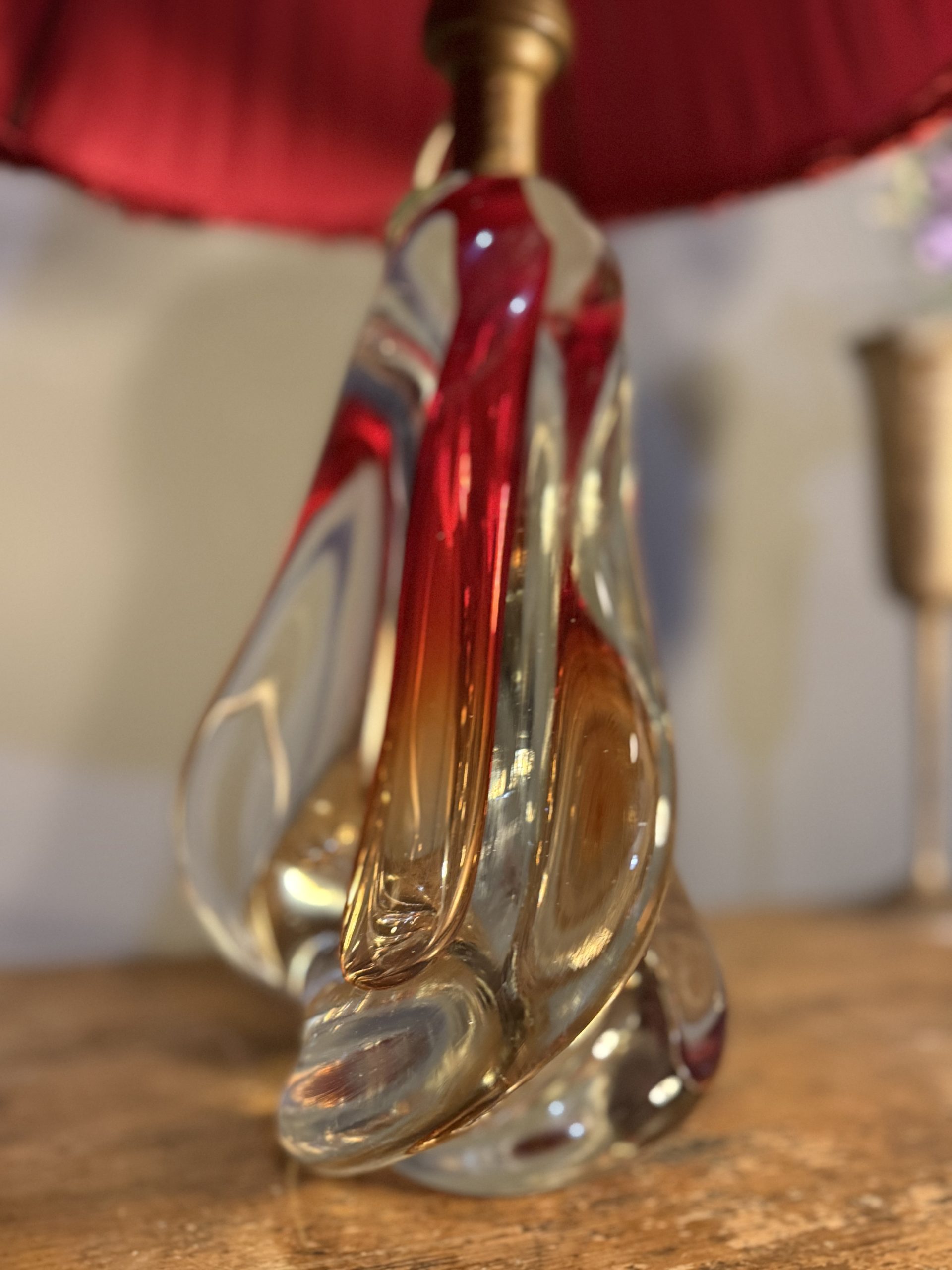 Lampă de masă din cristal masiv, cu formă sculpturală și abajur vechi din material textil roșu. Înălțime totală 47 cm.