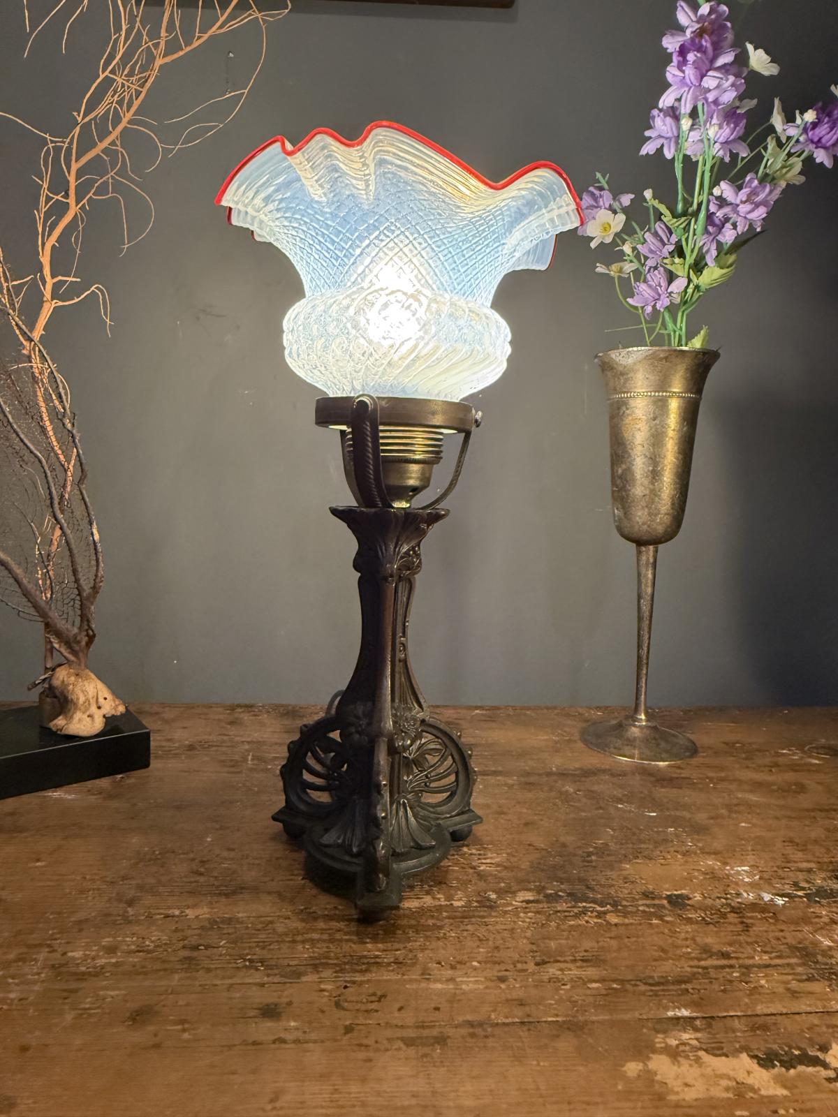 Lampă veche cu picior decorativ din zamac și glob din sticlă presată, cu margine ondulată roșie. Instalație electrică refăcută.