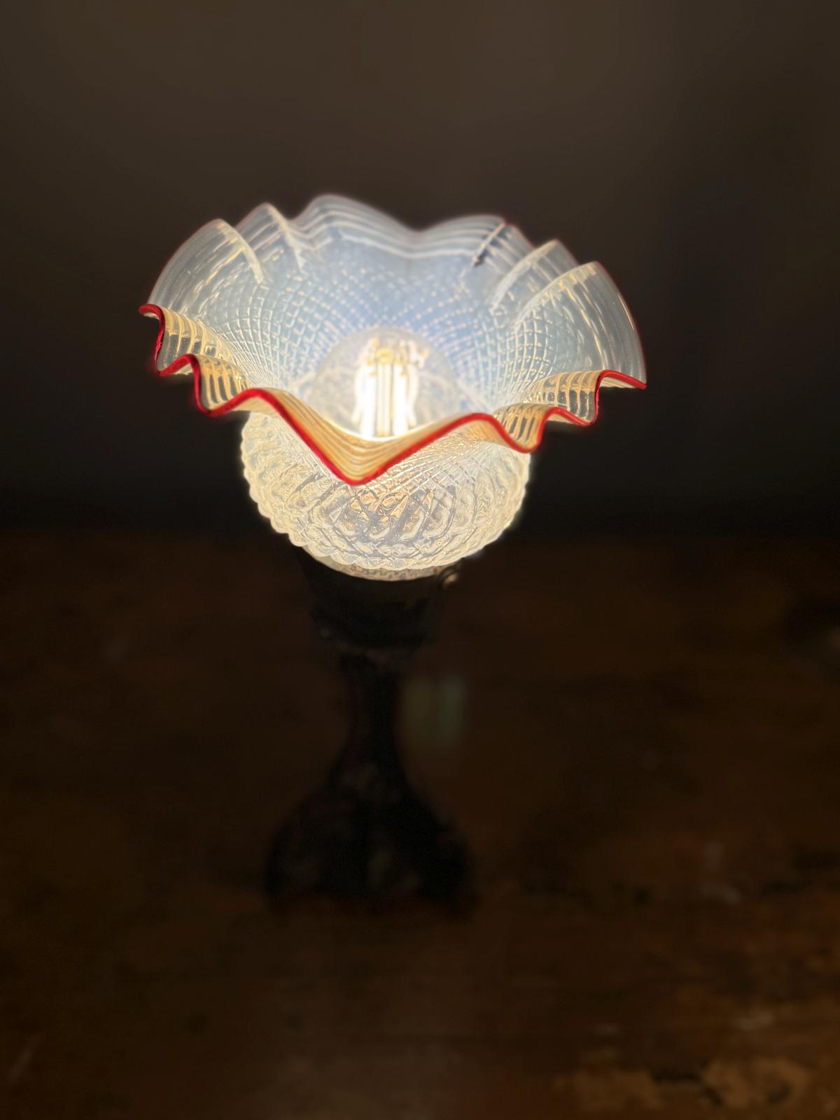 Lampă veche cu picior decorativ din zamac și glob din sticlă presată, cu margine ondulată roșie. Instalație electrică refăcută.