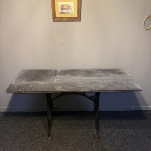 Masă realizată dintr-un picior vechi de mașină de cusut Dürkopp și un blat mare din marmură neagră, cu patină și urme de utilizare.