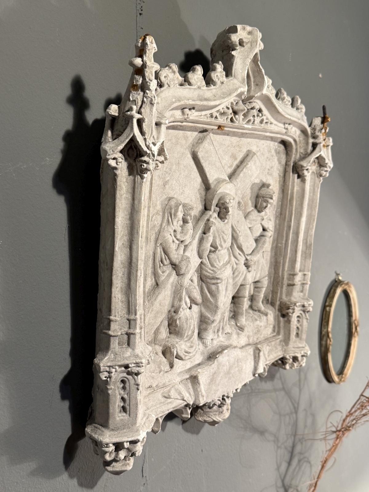 Basorelief religios din ipsos, cu Iisus purtând crucea și femeile din Ierusalim, în ancadrament neogotic. Dimensiuni 33 × 38 cm, cu patină și lipsuri.