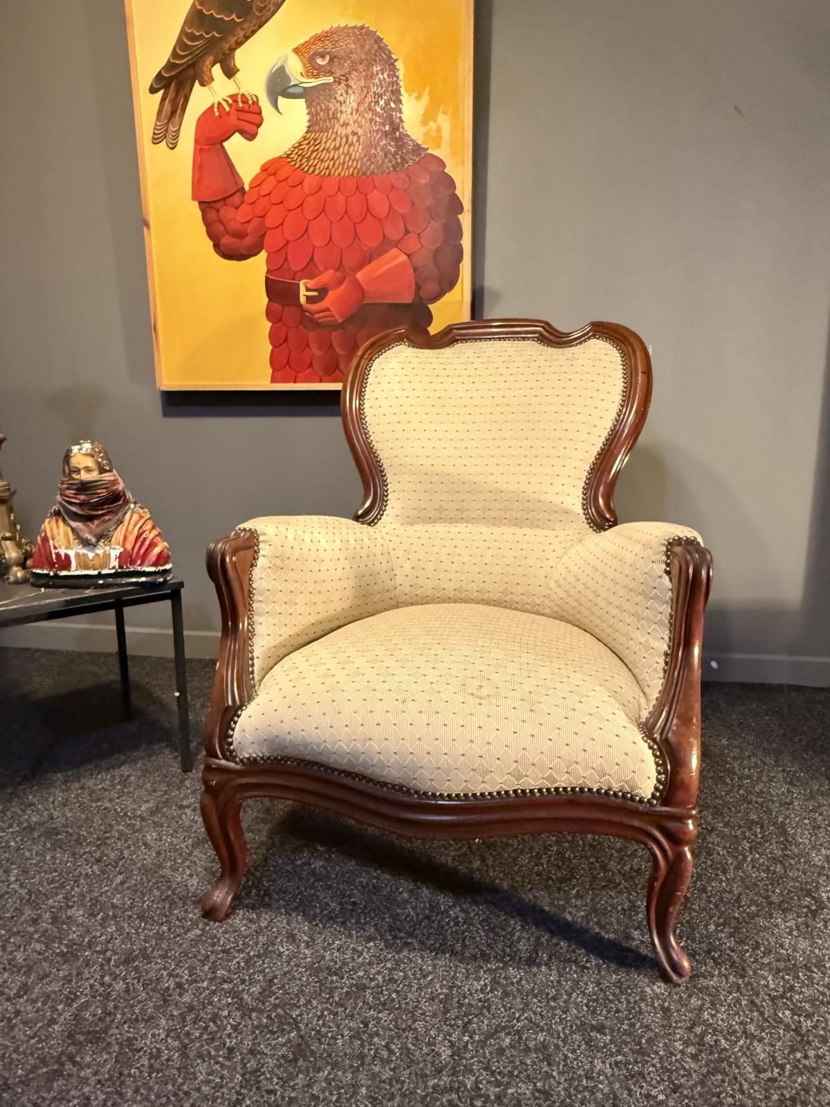 Fotoliu bergère în stil Louis XV, cu lemn brun și tapițerie crem. Confortabil și stabil, adus din Belgia. La Sertar Magic, București.
