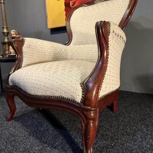 Fotoliu bergère în stil Louis XV, cu lemn brun și tapițerie crem. Confortabil și stabil, adus din Belgia. La Sertar Magic, București.