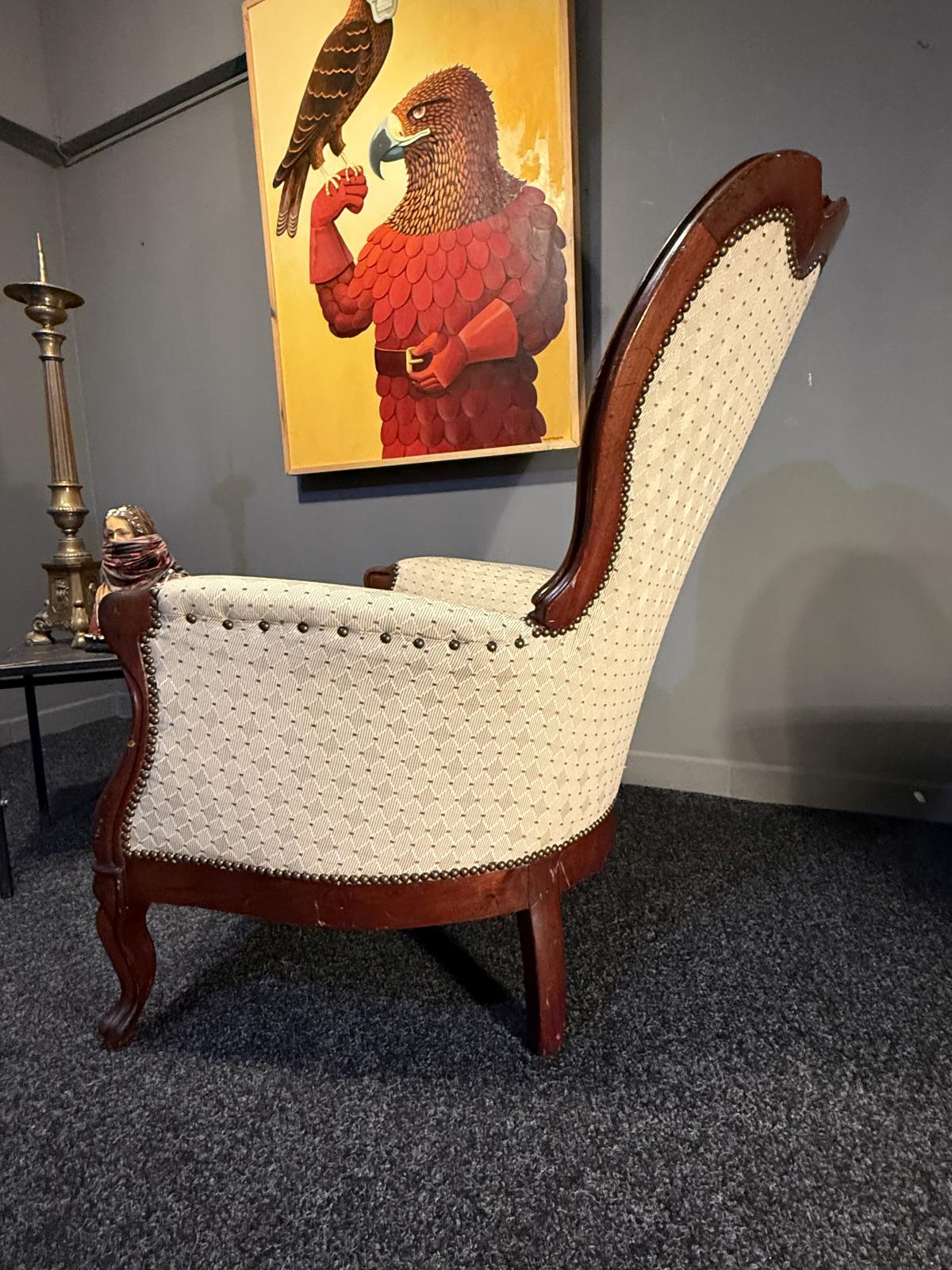 Fotoliu bergère în stil Louis XV, cu lemn brun și tapițerie crem. Confortabil și stabil, adus din Belgia. La Sertar Magic, București.