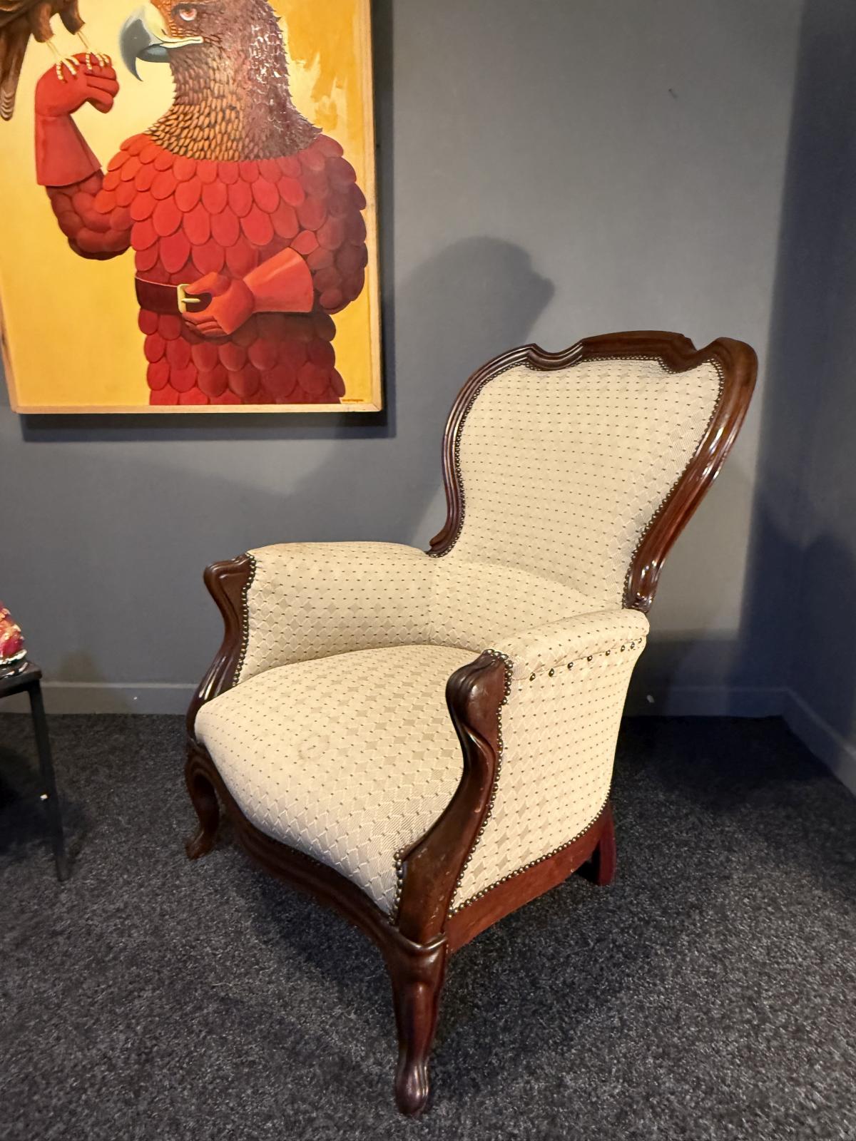 Fotoliu bergère în stil Louis XV, cu lemn brun și tapițerie crem. Confortabil și stabil, adus din Belgia. La Sertar Magic, București.