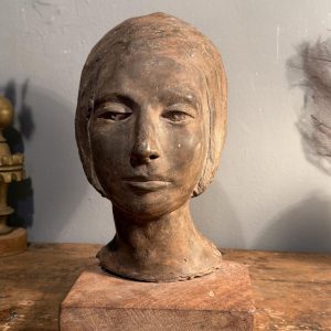 Sculptură reprezentând un cap de femeie, semnată CD și montată pe soclu din lemn. Descoper-o la Sertar Magic București.