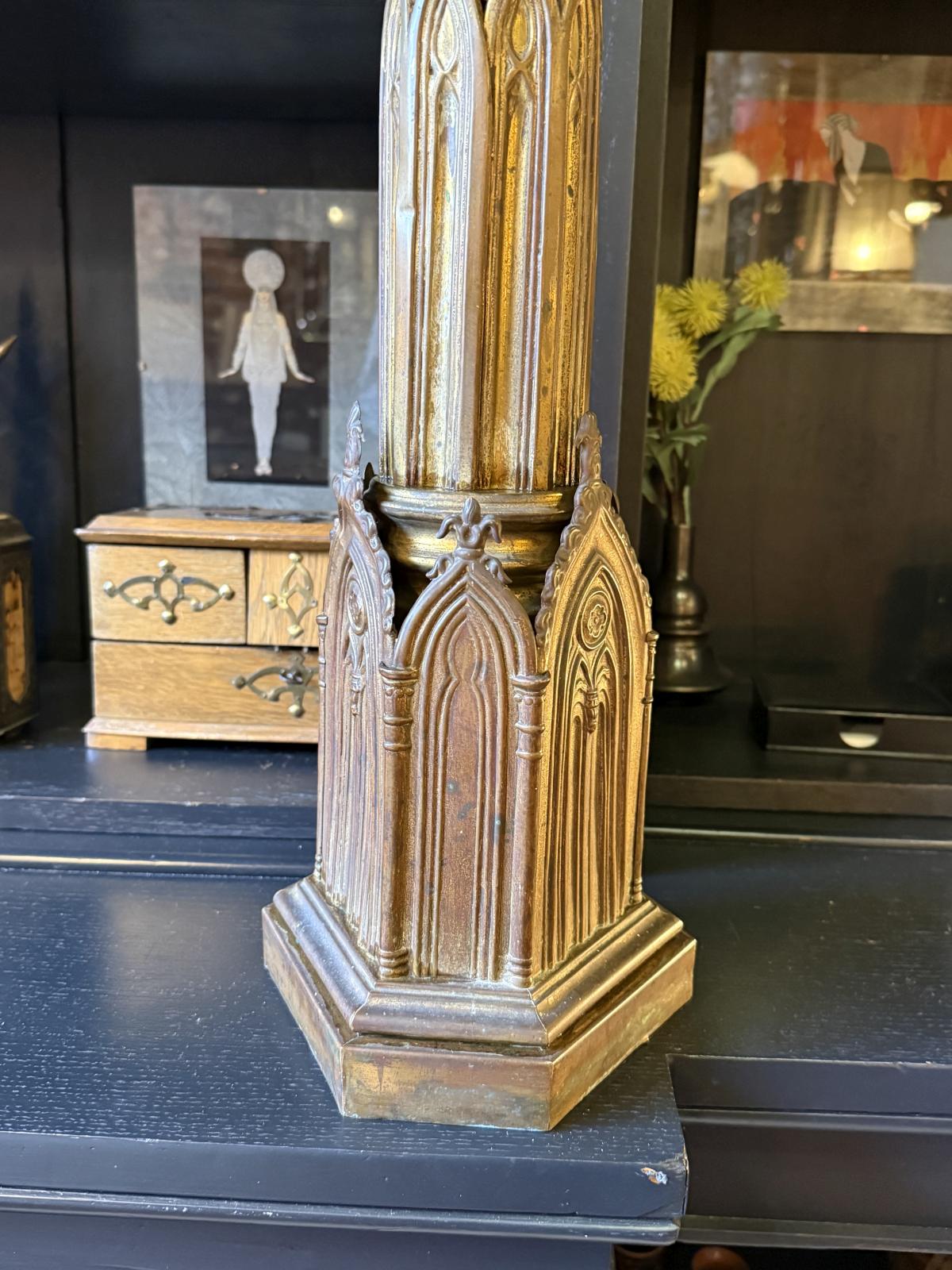Sfeșnic înalt din alamă în stil neogotic, cu arcade ogivale, patină închisă și bază stabilă. Înălțime 88 cm fără lumânare. Lumânare inclusă.